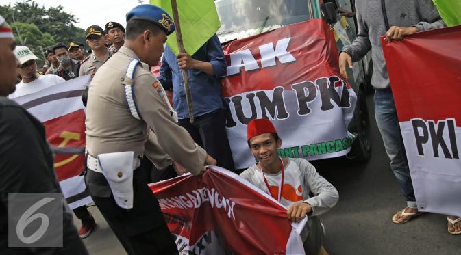 Aparat berusaha membubarkan massa aksi dari Front Pancasila saat berusaha masuk menuju Hotel Aryaduta, Jakarta, Senin (18/4). Mereka menolak Simposium PKI yang bertentangan dengan Pancasila dan UUD 1945. (Liputan6.com/Faizal Fanani)