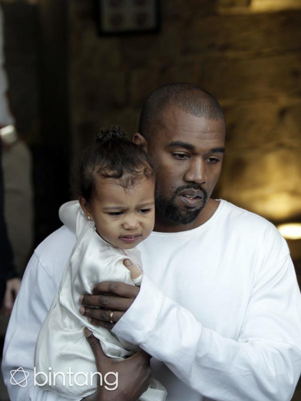 Kanye West memeluk North, namun North hanya meringis (via AFP/Bintang.com)