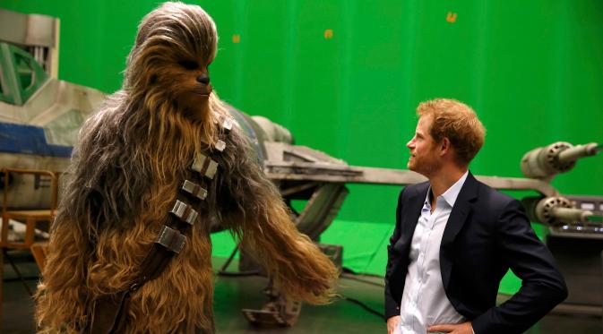 Pangeran Harry bertemu Chewbacca saat berkunjung ke studio pembuatan film Star Wars di Pinewood Studios, London, Selasa (19/4). Pangeran William dan Harry berkeliling Pinewood untuk mengunjungi workshop produksi film Star Wars (REUTERS/Adrian Dennis/Pool)