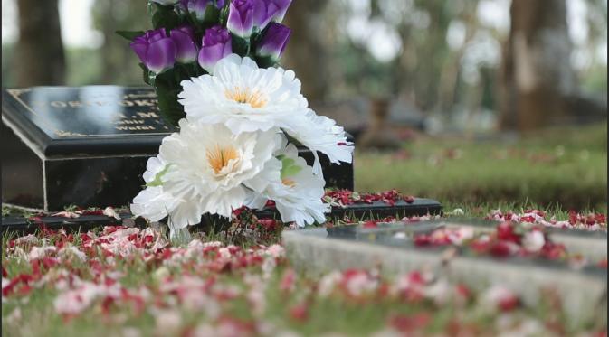 Karangan bunga diletakkan di batu nisan sebuah kuburan di Taman Pemakaman Umum di Jakarta Selatan.  (Liputan6.com/Heppy Wahyudi)