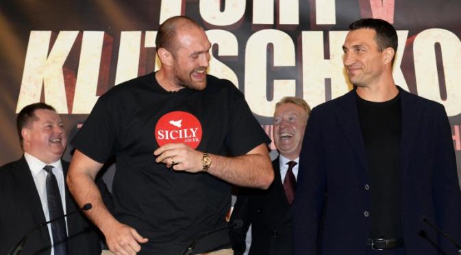 Tyson Fury (kiri) bercanda dengan Wladimir Klitschko saat konferensi pers menjelang rematch keduanya di Manchester, Inggris, Rabu (27/4/2016). (EPA/Phil Richards)