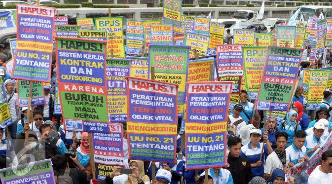 Buruh memadati halaman gedung DPR saat memperingati May Day 2016, Jakarta, Minggu (1/5). Massa yang tergabung dalam Serikat Pekerja Nasional (SPN) ini membawa 12 tuntutan diantaranya hapuskan BPJS. (Liputan6.com/Helmi Afandi)