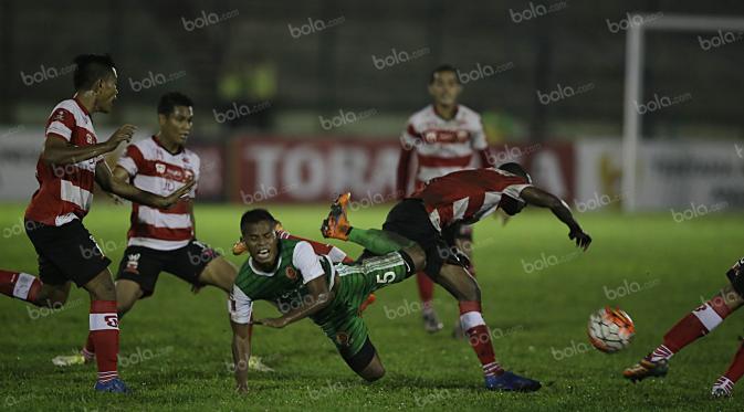 Pemain PS TNI, Manahati Lestusen, berebut bola dengan pemain Madura United, dalam laga Torabika Soccer Championship presented by IM3 Ooredoo di Stadion Siliwangi, Bandung, Minggu (1/5/2016). (Bola.com/Vitalis Yogi Trisna)