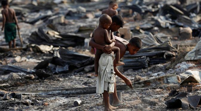 Sejumlah anak mencari barang yang tersisa dari kebakaran kamp pengungsi Muslim Rohingya di Rakhine, Myanmar, Selasa (3/5). Kamp itu tempat penampungan kelompok Rohignya yang tersingkir dari pertikaian dengan kelompok lain pada 2012. (REUTERS/Soe Zeya Tun)