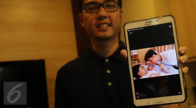 Rizky Kinos menunjukkan foto buah hatinya seusai jumpa wartawan di Rumah Sakit Omni, Jakarta, Rabu (4/5). Anak laki-laki Nycta Gina dan Rizky Kinos diberi nama Panutan Adhya Semesta Trinycta. (Liputan6.com/Herman Zakharia)