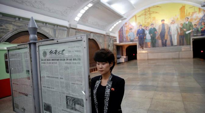 Seorang wanita membaca koran di stasiun bawah tanah yang dulunya merupakan lokasi rahasia (Reuters)