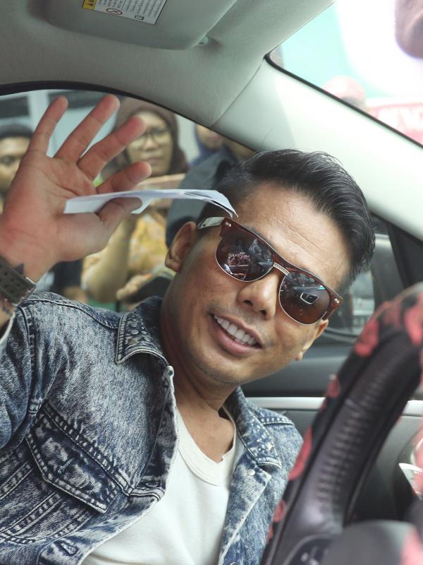 Muncikari artis, Robby Abbas menyapa para pewarta dari dalam mobil yang menjemputnya di LP Cipinang, Jakarta, Selasa (10/5). Sebelumnya, Robby diciduk polisi di sebuah hotel bintang lima di Kuningan, Jakarta pada 8 Mei 2015. (Liputan6.com/Herman Zakharia)