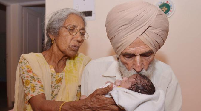  Daljinder Kaur (kiri) bersama sang suami Mohinder Singh Gill saat mengasuh anak mereka di Amritsar, India, (11/5).Setelah menikah selama 46 tahun, pasangan lansia ini akhirnya berhasil memiliki buah hati melalui program bayi tabung.( NARINDER NANU / AFP)
