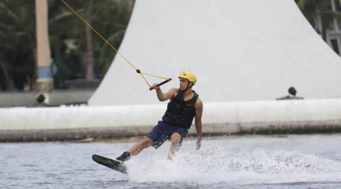 Pebalap GP2, Philo Paz Armand, memperlihatkan kelihaiannya dalam bermain wakeboard dengan memegang tali hanya menggunakan satu tangan. (Bola.com/Vitalis Yogi Trisna)