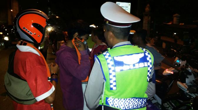 Polisi menilang sejumlah Jakmania atau suporter Persija di jalan menuju Stadion GBK, Senayan, Jakarta Pusat. (Liputan6.com/Nanda Perdana Putra)