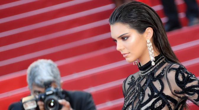Model cantik Kendall Jenner berpose saat menghadiri premier film From The Land of the Moon pada Festival Film Cannes ke-69 di Prancis, Minggu (15/5). Adik tiri Kim Kardashian itu tampak memesona dengan gaun hitam transparan. (Valery Hache/AFP)