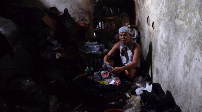 Untuk membayar utang-utangnya, Bripka Seladi memilih mengumpulkan sampah dibantu anak lelakinya. (Liputan6.com/Zainul Arifin)