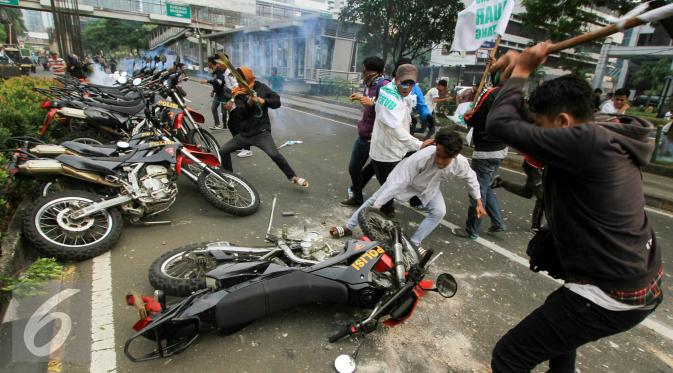 Massa merusak motor polisi yang terparkir di depan Gedung KPK, Jakarta, Jumat (20/5). Aksi menuntut KPK untuk segera mengusut keterlibatan Ahok di Sumber Waras ini berakhir ricuh. (Liputan6.com/Yoppy Renato)