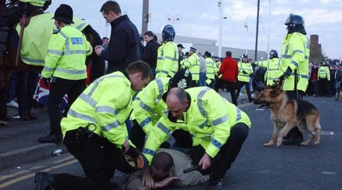 Polisi mengamankan hooligan yang terlibat kerusahan usai pertandingan Inggris melawan Turki, di Stadium of Light, Sunderland, 2003. (Daily Mail). 