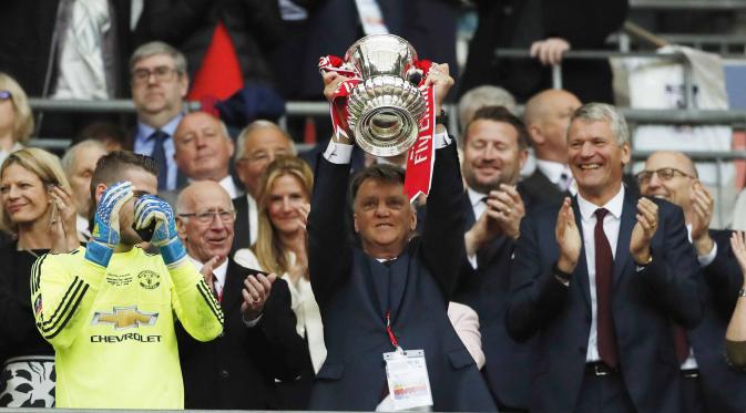 Louis van Gaal saat mengangkat torfi Piala FA usai mengalahkan Crystal Palace di Stadion Wembley, Inggris, (21/5/2016). (Reuters/John Sibley)