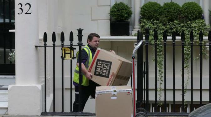 Seorang pria tampak mengangkut barang-barang dari kediaman Jose Mourinho di London (SWNS)