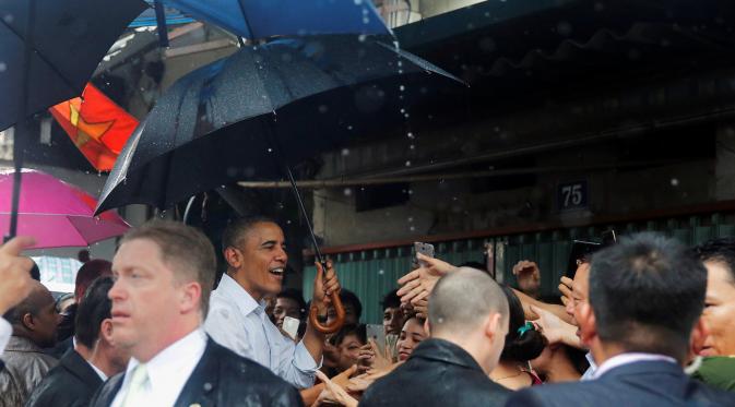 Presiden AS, Barack Obama menyapa warga usai wawancara dengan Anthony Bourdain di area perbelanjaan Hanoi, Vietnam (24/5). Kunjungan Obama ke Vietnam untuk mengakhiri larangan penjualan perlengkapan militer kepada pihak Hanoi. (REUTERS/Carlos Barria)