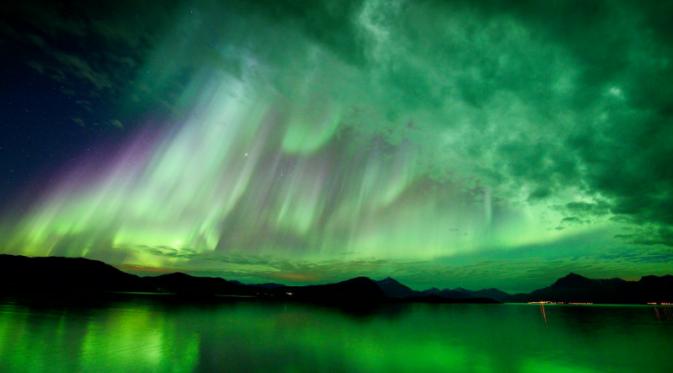 Aurora terjadi karena interaksi antara medan magnetik dengan partikel bermuatan yang dipancarkan oleh Matahari (NASA/ Hugo Løhre).