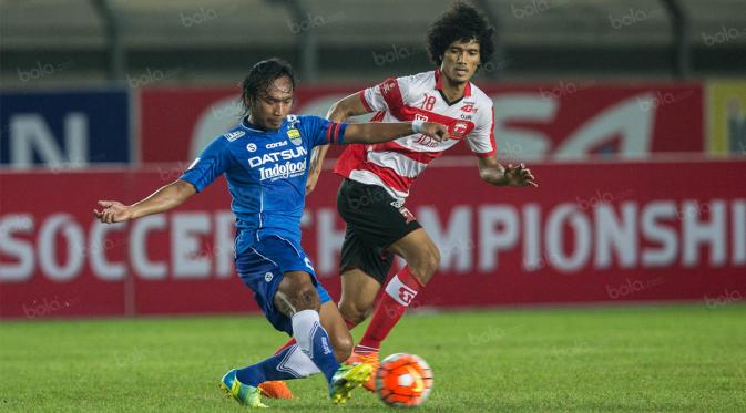 Gelandang Persib, Hariono, berhasil melewati gelandang Madura United, Ahmad Maulana, pada laga Torabika Soccer Championship 2016 di Stadion Si Jalak Harupat, Sabtu (28/5/2016). Kedua tim bermain imbang 0-0. (Bola.com/Vitalis Yogi Trisna)