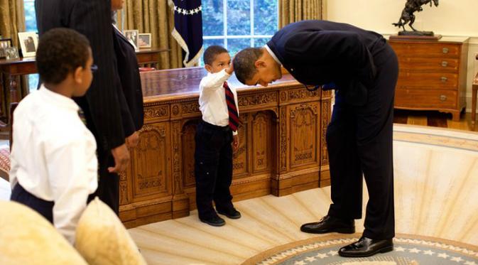 Tampak seorang anak memegang rambut Obama (Pete Souza).