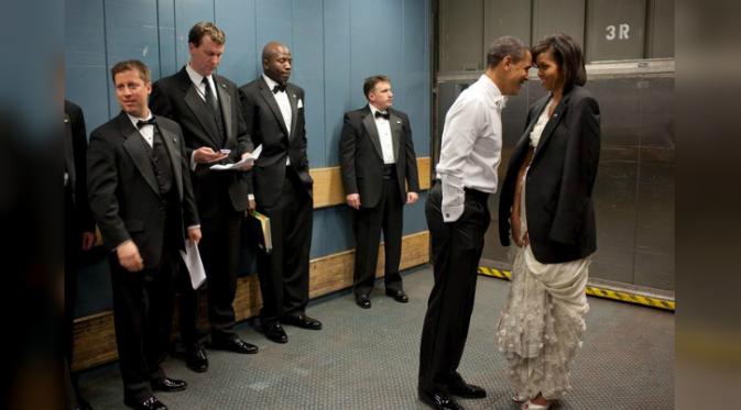 Obama menyenderkan keningnya di kening istrinya (Pete Souza).