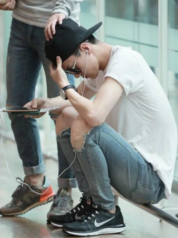 Sehun `EXO` yang terlihat duduk dengan menundukkan kepala (Koreaboo)