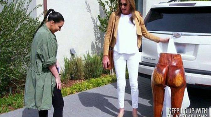 Kim Kardashian tak bisa menahan tawa saat Caitlyn Jenner memberinya patung kayu berbentuk bokong. (via. Aceshowbiz) 