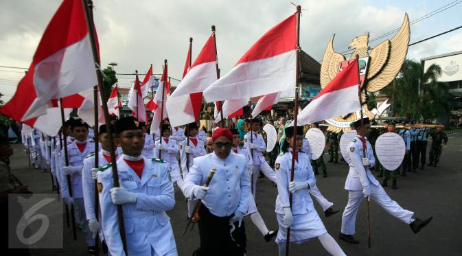 Peserta membawa bendera Merah Putih saat mengikuti pawai dengan membawa lambang Garuda Pancasila di Jl Malioboro, Yogyakarta,  (01/6/2016).Pawai di selenggarakan untuk memperingati hari lahir Pancasila.(Boy Harjanto)