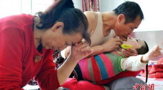 Cinta dan kasih sayang pasangan suami istri ini tidak pernah berkurang sedikitpun bagi putrinya yang menderita cerebral palsy.(Shanghaiist.com)
