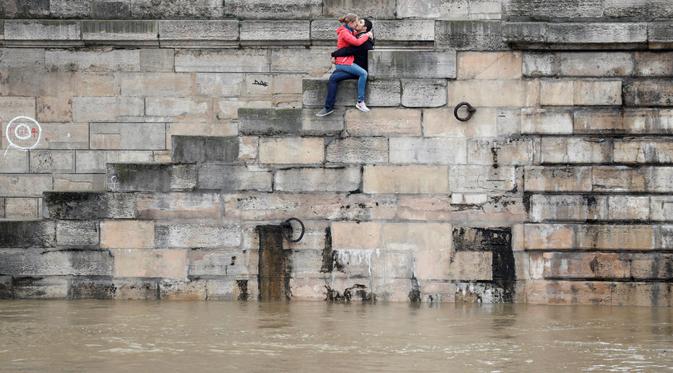 Sepasang kekasih bercumbu di sebuah bank dekat Sungai Seine. (pinterest.com)