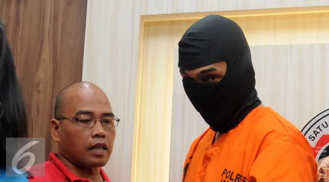 Restu Sinaga mengenakan baju tahanan dan penutup wajah. [Foto: Herman Zakharia/Liputan6.com]