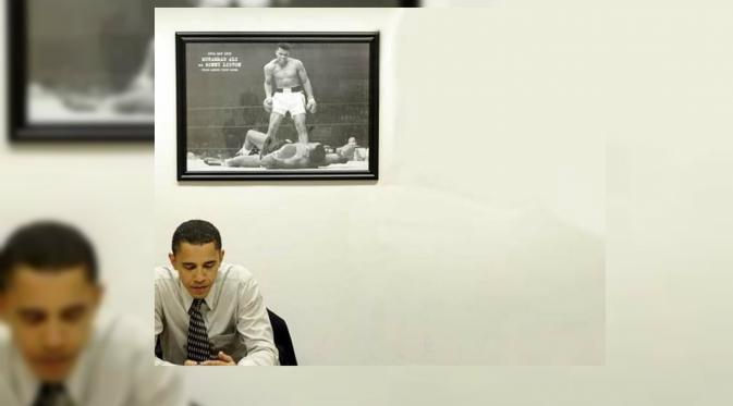 Obama di ruang kerja pribadinya. Di belakangnya tertera foto Muhammad Ali. (AFP)