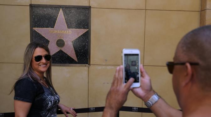  Pengunjung berfoto di depan bintang Muhammad Ali di Hollywood Walk of Fame, Sabtu (4/6/2016) waktu setempat. (EPA/Mike Nelon)