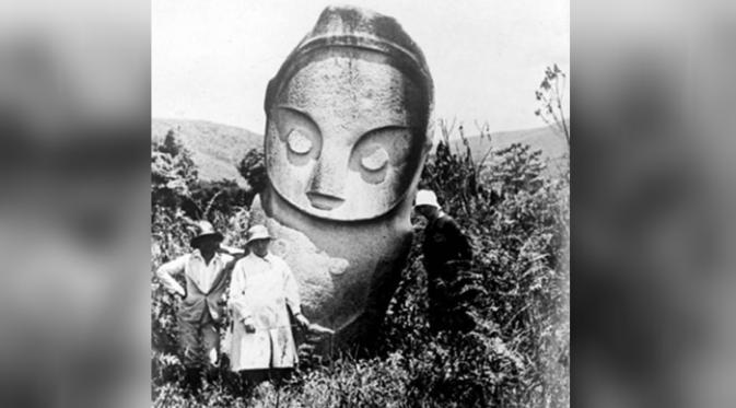 Beberapa orang berdiri di depan sebuah patung megalitik pada 1930-an (Tropenmuseum)
