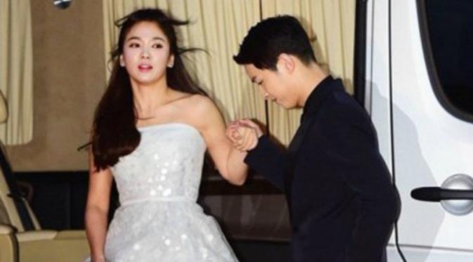 Song Joong Ki tampak seperti pangeran yang menyambut sang putri yang baru datang, Song Hye Kyo di acara penghargaan Baeksang Arts Awards 2016 (foto: Korea.com)