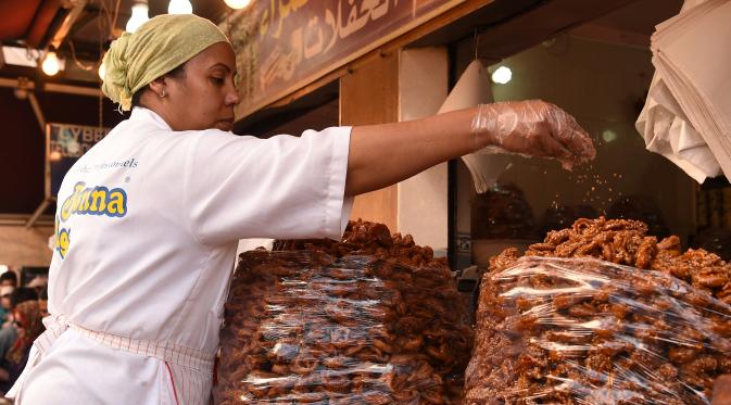 Pedagang menaburkan wijen ke atas Chebakia, kuliner asli dari Maroko, yang dijajakan di Ibu Kota Maroko, Rabat, 6 Juni 2016. Kehadiran penganan ini menandai datangnya bulan Ramadan atau peristiwa penting. (Fadel SENNA/AFP)