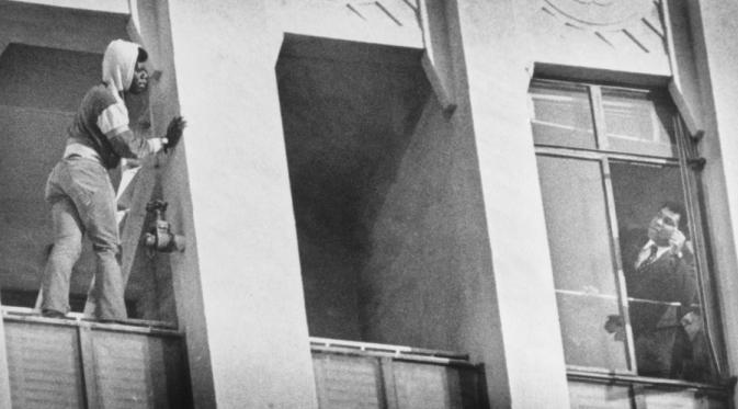 Muhammad Ali (kanan) saat mencoba membujuk seorang pria yang ingin mencoba bunuh diri dengan melompat dari salah satu gedung tinggi, di Amerika Serikat, pada 1981. (Bettmann/Corbis).