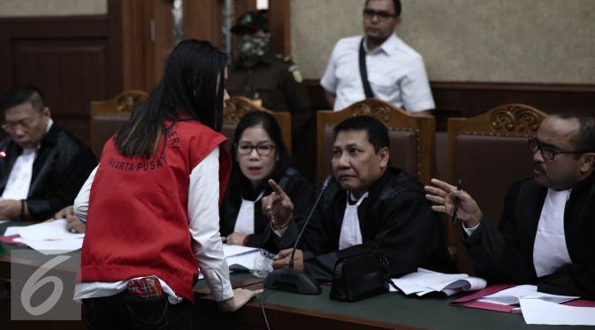 Jessica Kumala Wongso berdiskusi dengan kuasa hukumnya saat menjalani sidang perdana di PN Jakarta Pusat, Rabu (15/6). Dalam Sidang ini Jessica mengajukan eksepsi atau keberatan kepada majelis hakim. (Liputan6.com/Faizal Fanani)