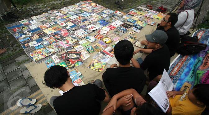 Sejumlah anggota Rumah Baca Komunitas (RBK) menggelar perpustakaan keliling di Alun-Alun Selatan Yogyakarta, 14 Juni 2016. Perpustakaan Jalanan RBK buka sore sambil Ngabuburead sampai jelang berbuka puasa. (Liputan6.com/Boy Harjanto)