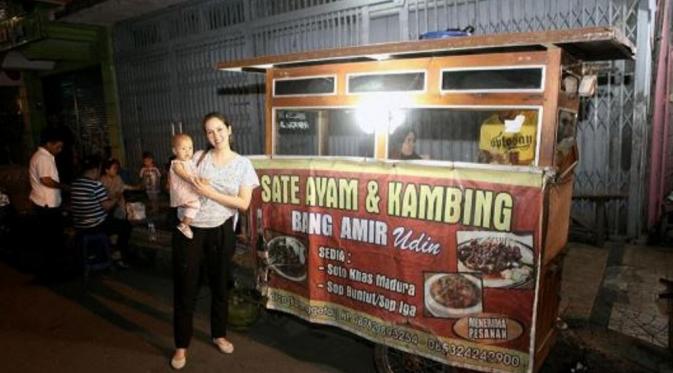 Cathy Sharon menggendong Carla di depan gerobak sate kaki lima di Cirebon, (Instagram)