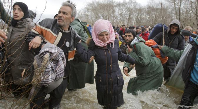 Tak mengenal cuaca, para pengungsi terus berpindah untuk temukan rumah baru. (Vadim Ghirda/AP)