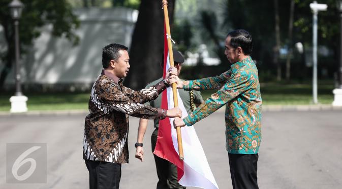 Presiden Jokowi menyerahkan bendera merah putih kepada Menpora Imam Nahrawi sebagai tanda pelepasan keberangkatan Tim Indonesia menuju Olimpiade 2016 di Brasil, di halaman Istana Merdeka, Jakarta, Rabu (22/6). (Liputan6.com/Faizal Fanani)
