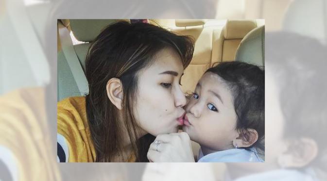 Ayu Ting Ting mengecup mesra bibir sang buah hati seraya berdoa kesembuhannya. (Instagram)