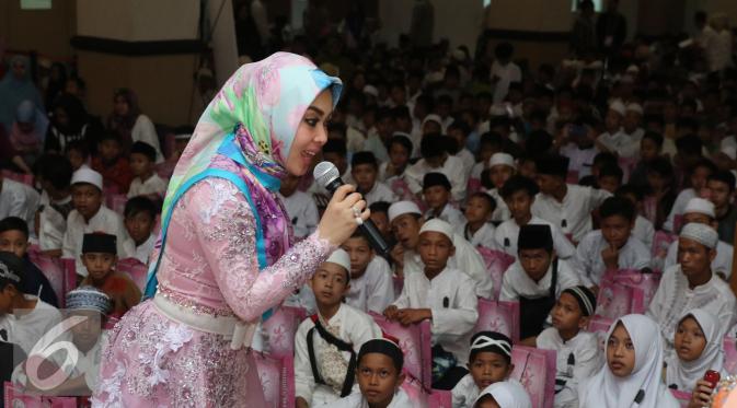 Syahrini berbincang dengan anak yatim di acara Tanda Cinta Princess Syahrini di Masjid Az-Zikra, Sentul, Bogor, Jumat (24/6). Syahrini berbagi rezeki dengan 5.000 anak yatim.  (Liputan6.com/Herman Zakharia)