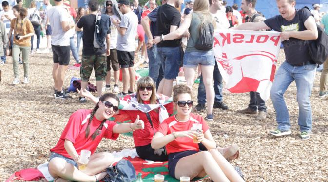 Para wanita suporter dari Wales menjadikan bendera negaranya sebagai alas duduk saat menyaksikan nonton bareng Piala Eropa 2016 di fan zone Kota Paris, Prancis, Sabtu (25/6/2016). (Bola.com/Vitalis Yogi Trisna).