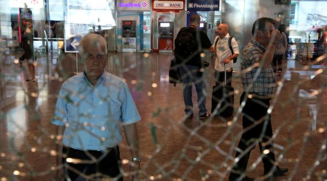 Seorang pria mengamati kaca jendela yang retak di Bandara Ataturk, Istanbul, Turki, Rabu (29/6). Aktivitas di bandara internasional tersebut berangsur normal pasca ledakan bom bunuh diri yang menewaskan 42 korban jiwa. (REUTERS/Goran Tomasevic)