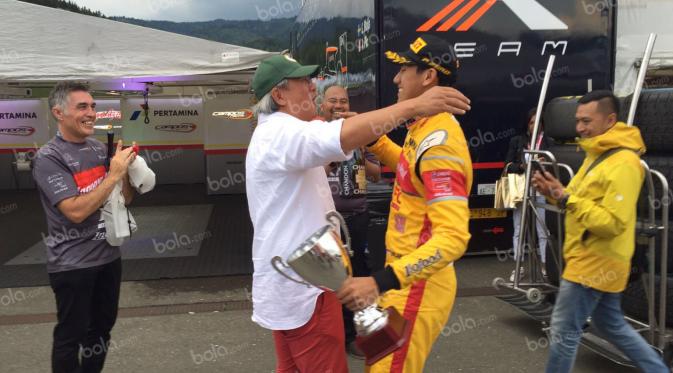 Pebalap Campos Racing asal Indonesia, Sean Gelael, disambut ayahnya, Ricardo Gelael, seusai finis posisi kedua feature race GP2 Austria di Sirkuit Red Bull Ring, Austra, Sabtu (2/7/2016). (Bola.com/Reza Khomaini)