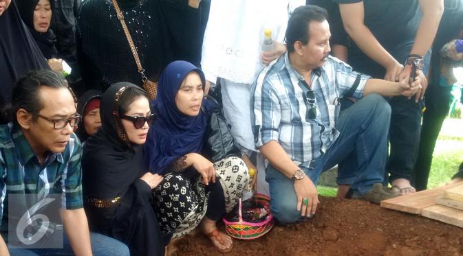 Kristina bersama saudaranya menyaksikan pemakaman sang bunda, Dariyah, di TPU Tanah Merah, Pondok Kopi, Jakarta. [Foto: Rizky Aditya Saputra/Liputan6.com]