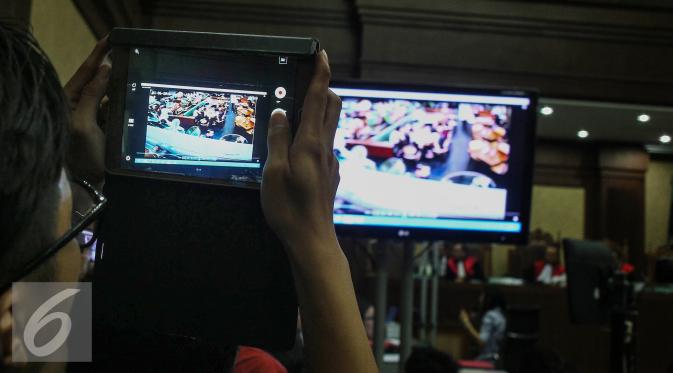 Pengunjung sidang mengabadikan rekaman CCTV dalam persidangan saksi kasus pembunuhan Wayan Mirna Salihin di PN Jakarta Pusat, Rabu (13/7). Sidang menampilkan video CCTV yang berisi rekaman kejadian di Kafe Olivier. (Liputan6.com/Faizal Fanani)
