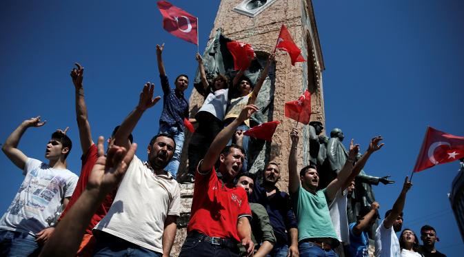 Pendukung Presiden Turki, Tayyip Erdogan meneriakkan slogan saat berdiri di sekitar Monumen Republik, pusat kota Istanbul, Sabtu (16/7). Ratusan warga turun ke jalan untuk merayakan kegagalan kudeta militer di Turki. (REUTERS/Alkis Konstantinidis)